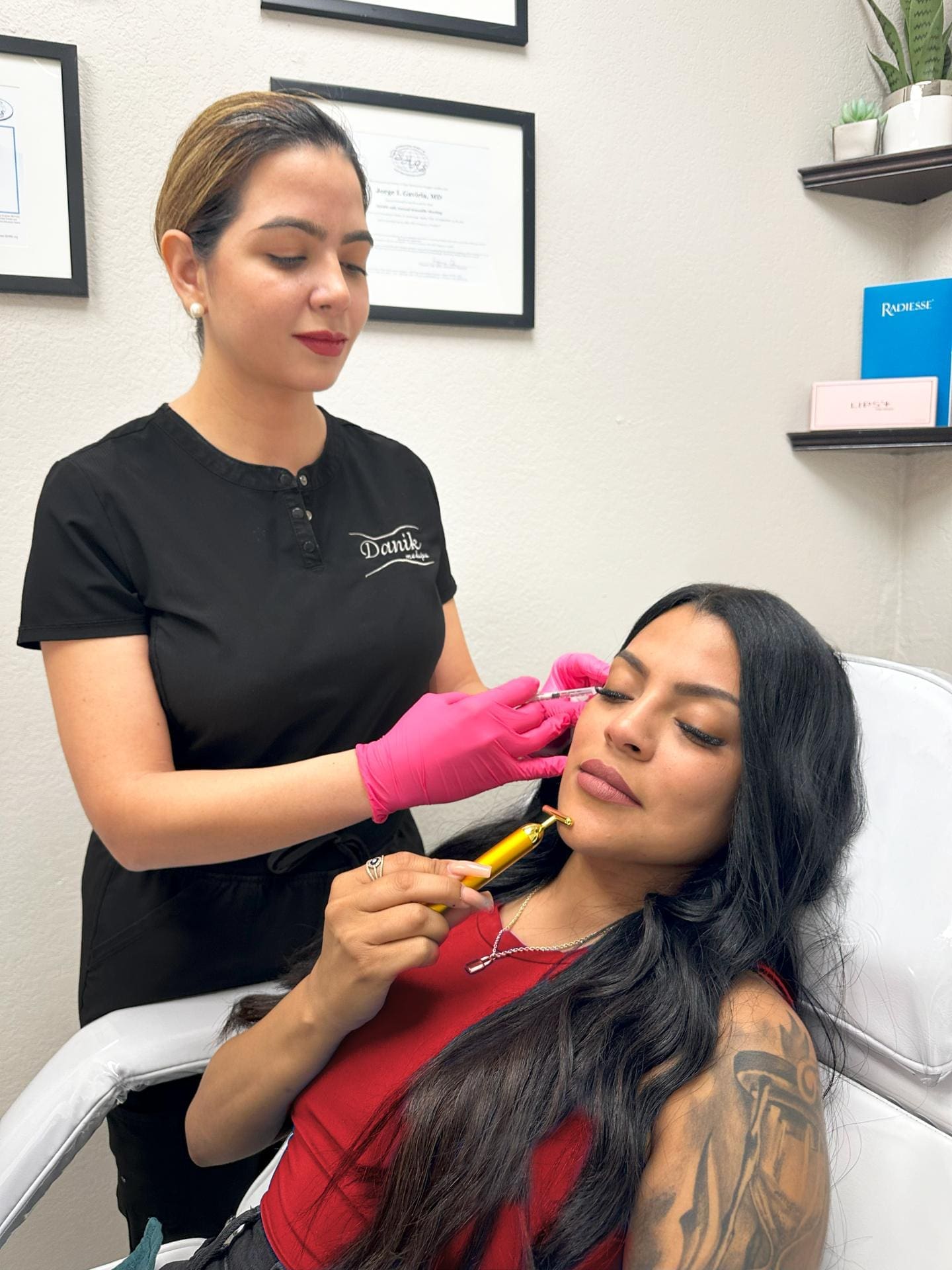 Woman Receiving A Xeomin Dermal Filler Injection Treatment For Her Skin While Holding A Facial Roller To Her Face