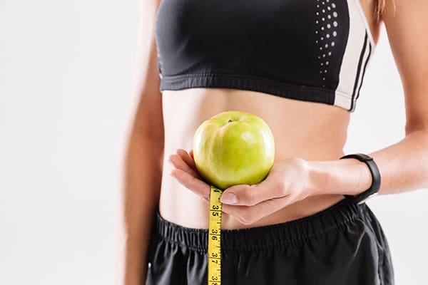 young woman holding an apple promoting weight loss injections at danik mespa