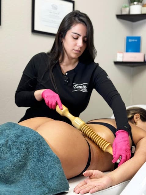 Specialist performing wood therapy on a client’s thighs at Danik MedSpa.